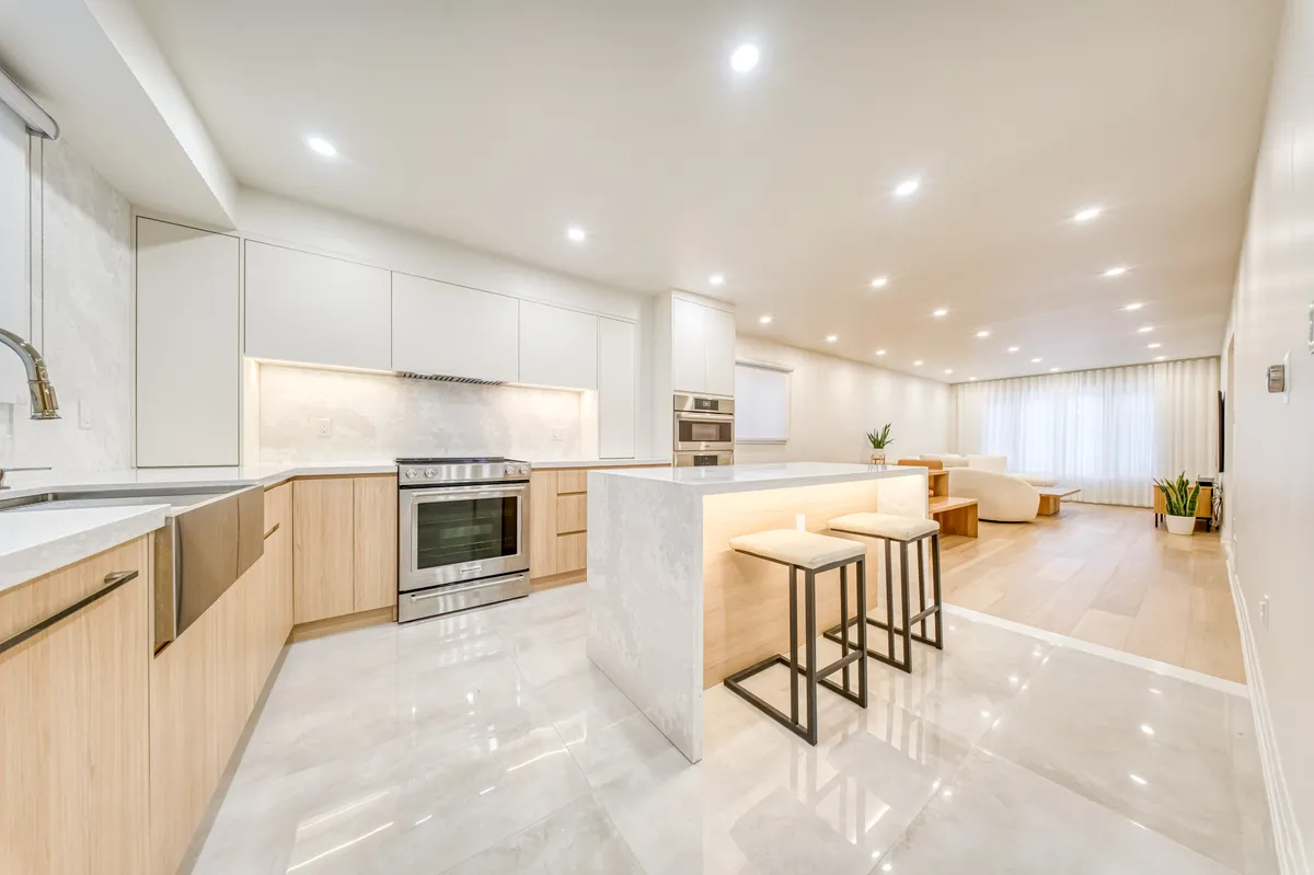 The kitchen: a stone waterfall island with stools, oak lowers and white uppers.