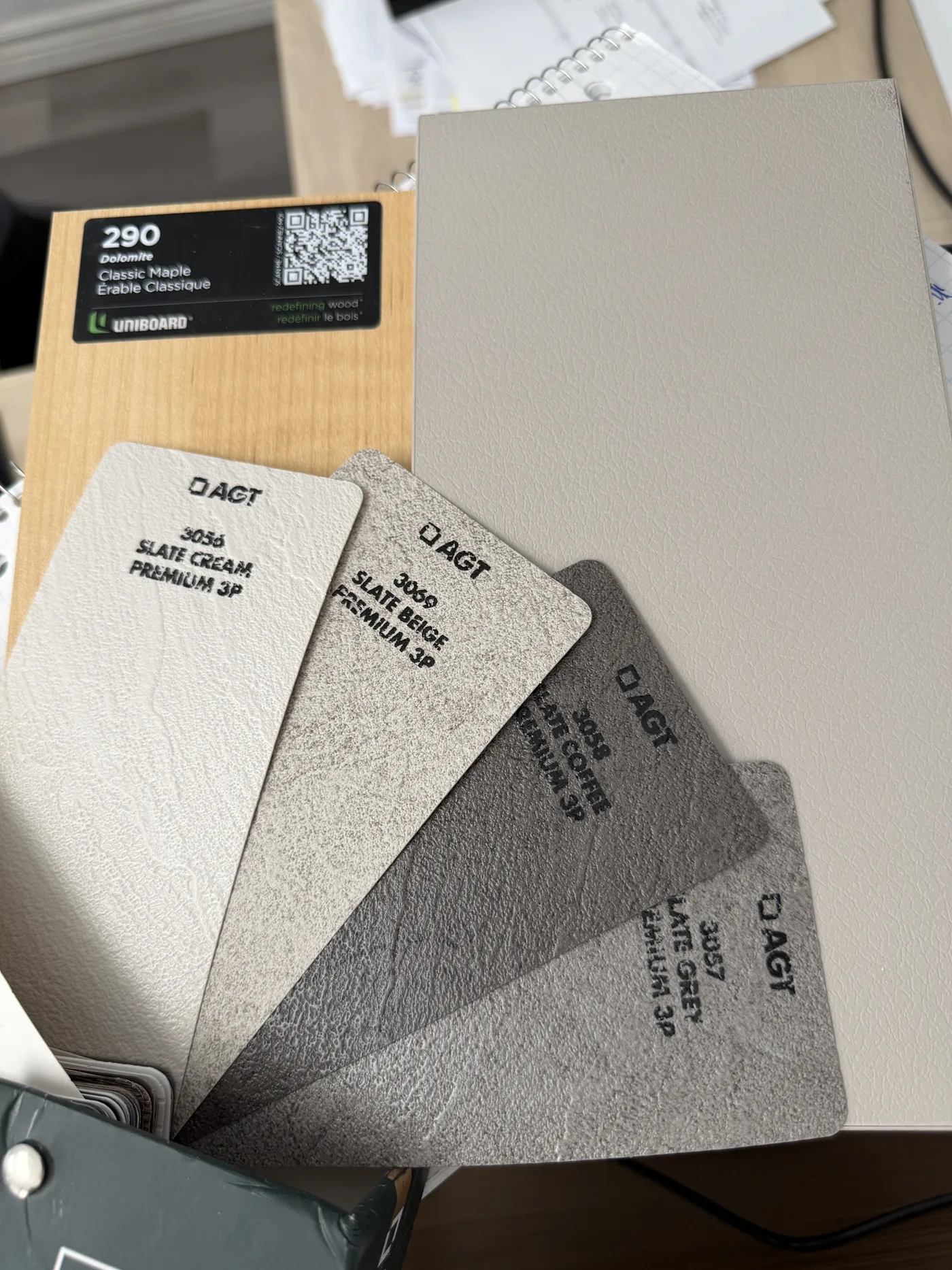 A fan of grey and cream cabinet colour samples.