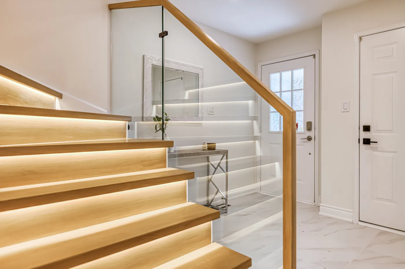 Oak stair treads lit from beneath, with a glass guard.