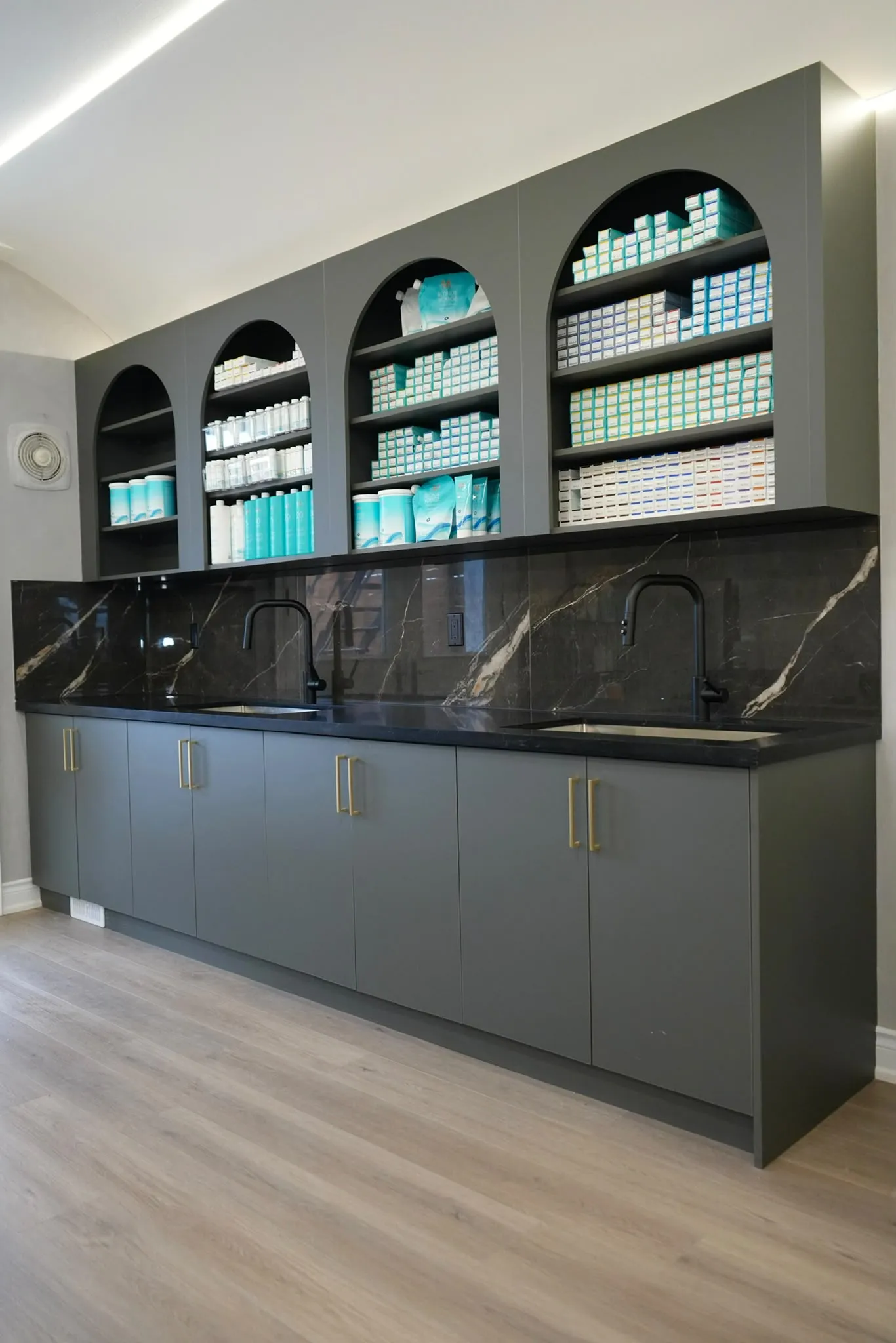 The finished back bar: lit arched shelves over dark stone.