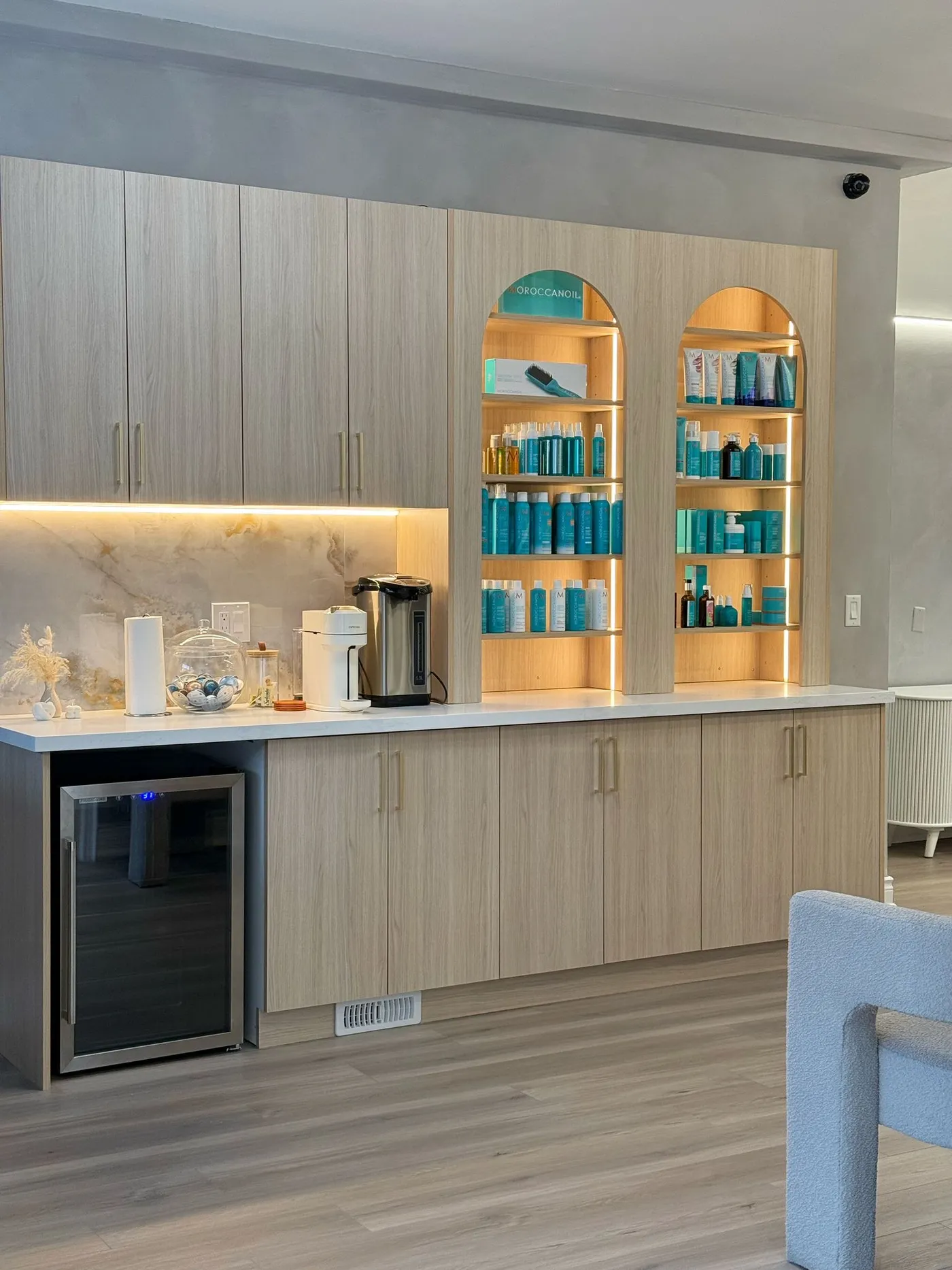 A drinks counter with lit arched shelves.